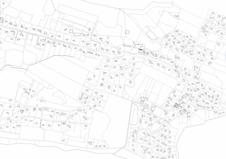 Carte cadastrale en noir et blanc montrant les limites des propriétés, les parcelles, les bâtiments et les routes dans une zone rurale. Une propriété proche du centre est délimitée en rouge, mettant en évidence une maison contemporaine parmi les champs, les maisons et les rues qui se croisent.